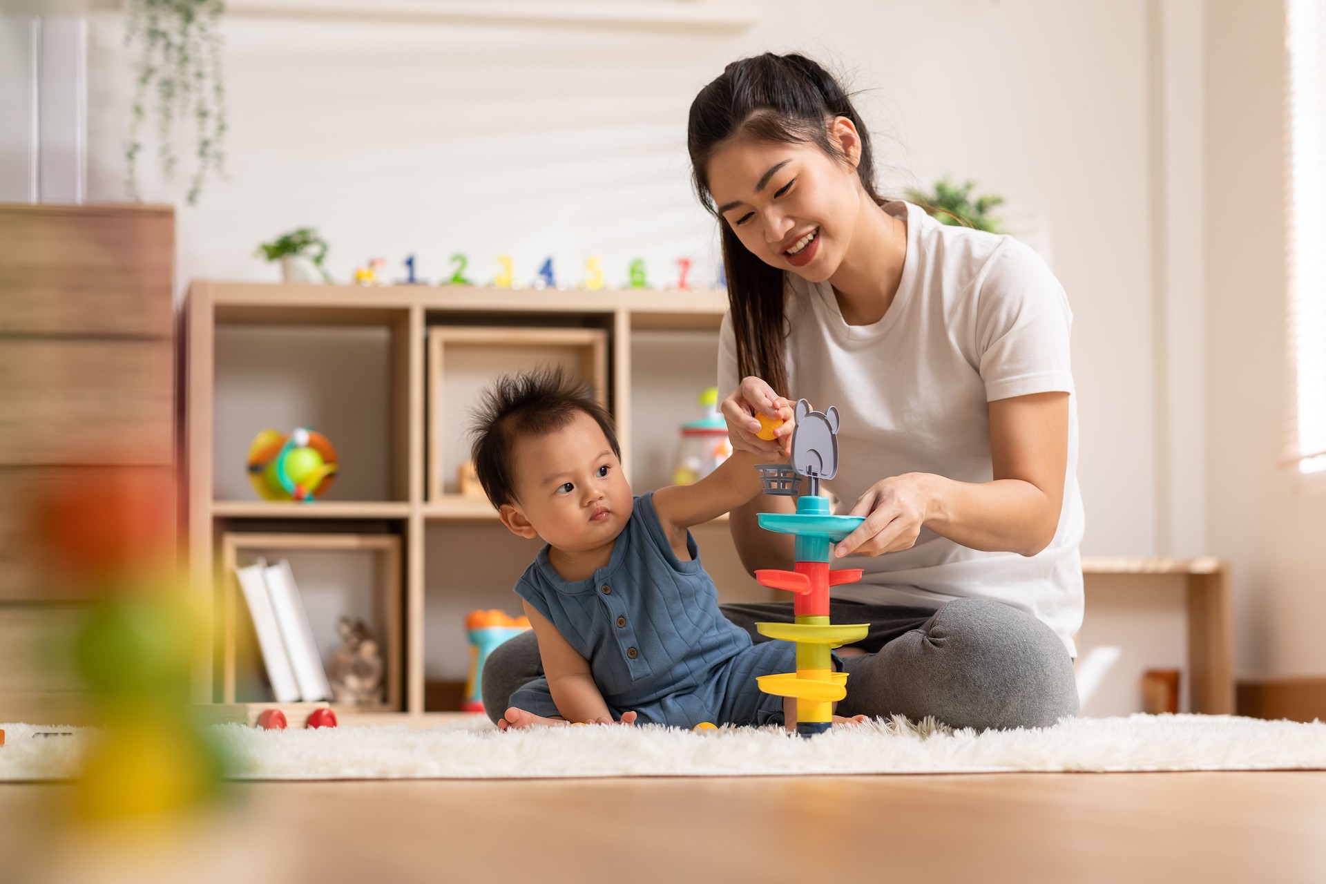 Asian mom teaching baby boy learning and playing toys for development skill at home or nursery room. Happiness mother and baby spending time together at warmth place. Good moment with mom and baby